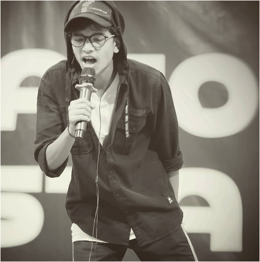 Kayden Sharma is performing on the mic.